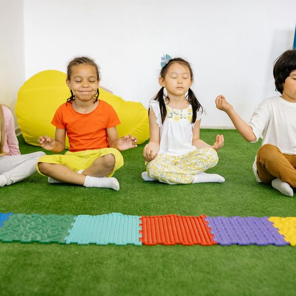 A group of children joyfully practicing yoga together.